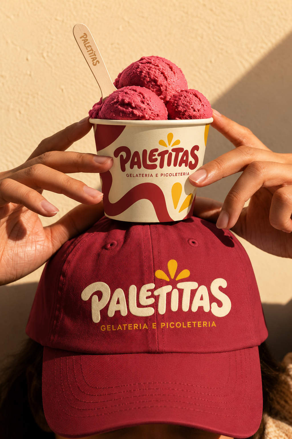 Copo de gelato da Paletitas apoiado em boné da marca
